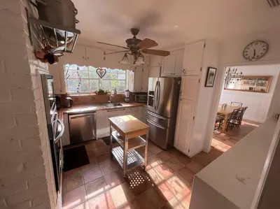 a kitchen with stainless steel appliances and a table at Villa Rustica 5 Bedroom 3 Bath with Pool Next to River 1800 in Miami