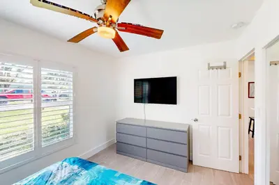 a bedroom with a ceiling fan and a tv at Palm Shadow Sanctuary in Fort Lauderdale