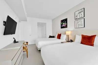 a hotel room with two beds and a flat screen tv at Beachfront Escape Pool Gym Stunning Views 30th floor in Hallandale Beach