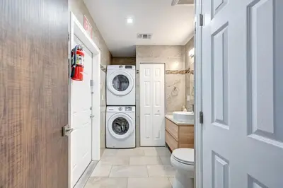 a bathroom with a washer and dryer in it at Luxury 4BR & 4BA Villa Heated Pool Minutes To Beach in Hollywood