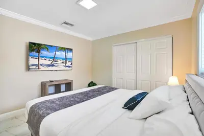 a bedroom with a white bed and a white door at Luxury 4BR & 4BA Villa Heated Pool Minutes To Beach in Hollywood