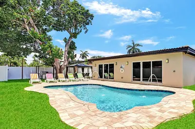 a swimming pool in the yard of a house at Luxury 4BR & 4BA Villa Heated Pool Minutes To Beach in Hollywood