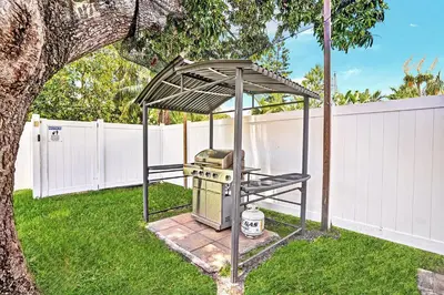 a grill under a canopy in a yard at Luxury 4BR & 4BA Villa Heated Pool Minutes To Beach in Hollywood