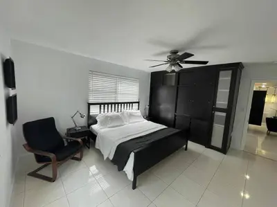 a bedroom with a bed and a chair and a ceiling fan at Stylish Home close to everything in Hollywood