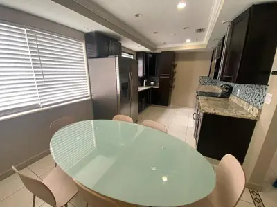a kitchen with a glass table and some chairs at Stylish Home close to everything in Hollywood