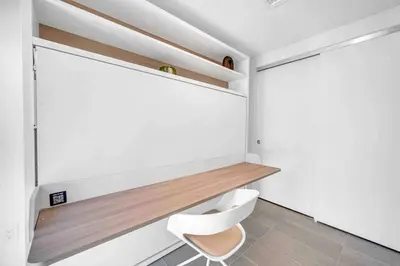 a bathroom with a white toilet and a wooden shelf at Breathtaking studio in the Heart Miami in Miami