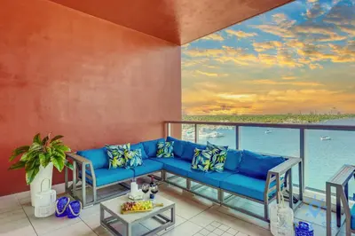 a living room with a blue couch and a view of the ocean at New Studio - Hollywood Beach Bliss for 2 in Hollywood