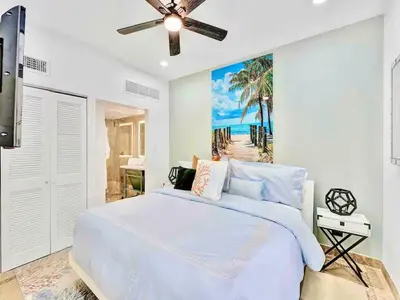 a bedroom with a white bed with a painting on the wall at Park Place South of Fifth in Miami Beach