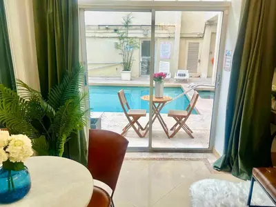 a room with a table and chairs and a pool at Park Place South of Fifth in Miami Beach