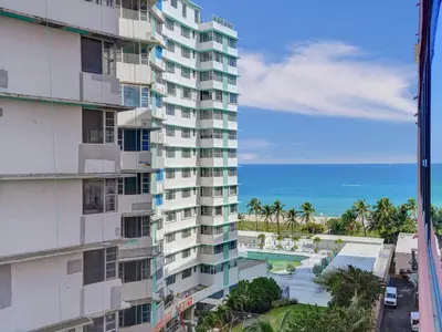 an apartment building with a swimming pool and the ocean at Beautiful Beach Condo Beach Service 1020 in Miami Beach