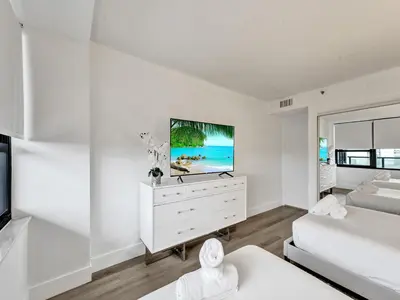 a white living room with a flat screen tv at Huge 2BD Miami beach with beach service -720 in Miami Beach