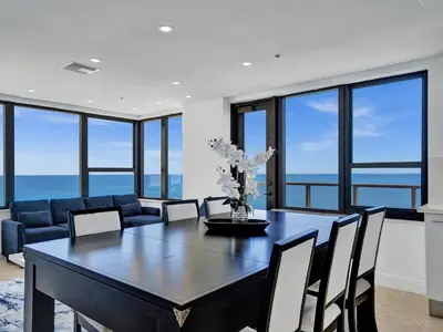 a dining room with a table and chairs and the ocean at Ocean Front Penthouse 2BD 2 Balconies PH-2 in Miami Beach