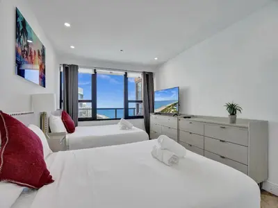 a bedroom with two beds and a large window at Ocean Front Penthouse 2BD 2 Balconies PH-2 in Miami Beach