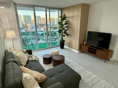 a living room with a couch and a flat screen tv at Ocean Reserve Condo by FlatsAway in Miami Beach