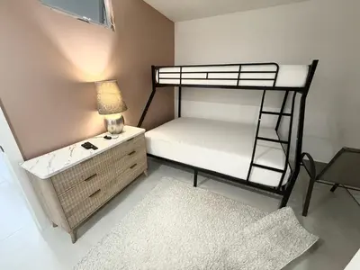 a bedroom with a bunk bed with a desk and a lamp at Ocean Reserve Condo by FlatsAway in Miami Beach