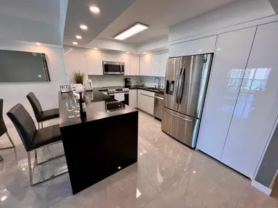 a kitchen with a stainless steel refrigerator and appliances at Ocean Reserve Condo by FlatsAway in Miami Beach