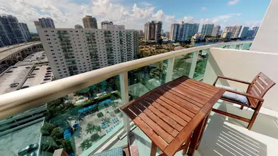 a balcony with a chair and a view of a city at Ocean Reserve Condo by FlatsAway in Miami Beach