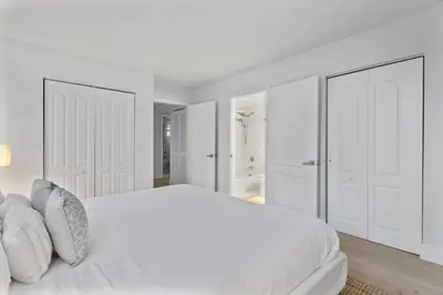 a white bedroom with white doors and a bed at myClub at Brickell Bay in Miami
