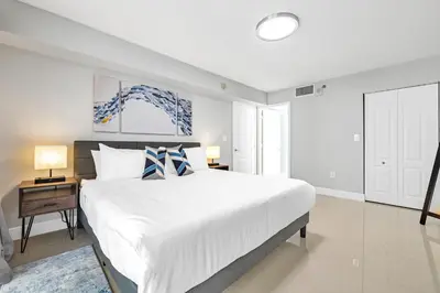 a bedroom with a large white bed and a night stand at myClub at Brickell Bay in Miami