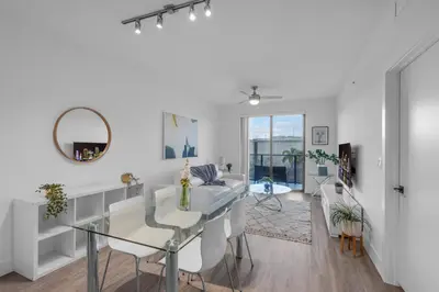 a white living room with a glass table and white chairs at Modern 1 Bedroom In The Heart Of Downtown Doral in Hialeah Gardens