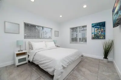 a white bedroom with a bed and two windows at Bayshore Breeze Free Parking 1 in Fort Lauderdale