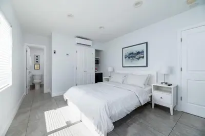 a white bedroom with a large bed and a bathroom at Bayshore Breeze 4 in Fort Lauderdale