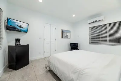 a white bedroom with a large bed and a window at Bayshore Breeze 6 in Fort Lauderdale
