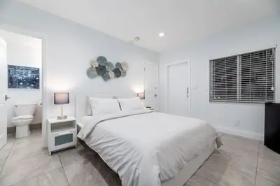 a white bedroom with a bed and a toilet at Bayshore Breeze 6 in Fort Lauderdale