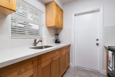 a kitchen with wooden cabinets and a sink and a window at Bayshore Breeze Free Parking 7 in Fort Lauderdale