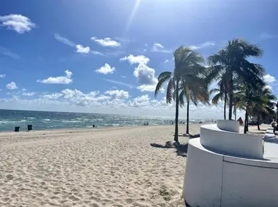 a sandy beach with palm trees and the ocean at Bayshore Breeze Free Parking 7 in Fort Lauderdale