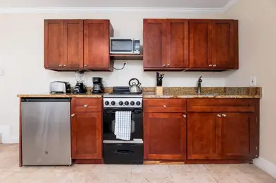 a kitchen with wooden cabinets and a stove at Ocean Breeze Free Parking Apt 2 in Fort Lauderdale