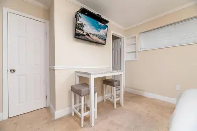 a bedroom with a desk and a tv on the wall at Ocean Breeze Free Parking Apt 2 in Fort Lauderdale