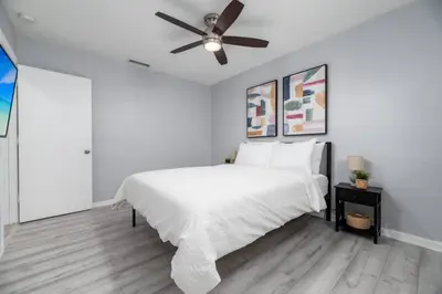 a white bedroom with a bed and a ceiling fan at Short Walk to Wilton Drive Apt2 in Fort Lauderdale