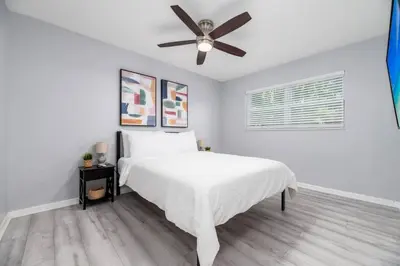 a white bedroom with a bed and a ceiling fan at Short Walk to Wilton Drive Apt2 in Fort Lauderdale