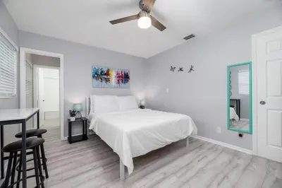 a white bedroom with a bed and a desk at Short Walk to Wilton Drive Apt5 in Fort Lauderdale