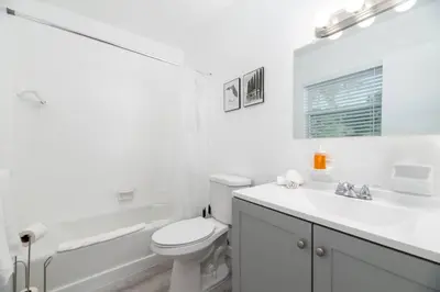 a white bathroom with a toilet and a sink at Short Walk to Wilton Drive Apt5 in Fort Lauderdale