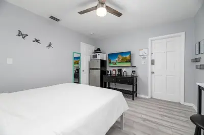 a white bedroom with a bed and a refrigerator at Short Walk to Wilton Drive Apt5 in Fort Lauderdale