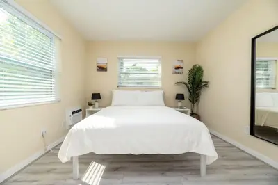 a bedroom with a white bed and a large window at Short Walk to Wilton Drive Apt6 in Fort Lauderdale