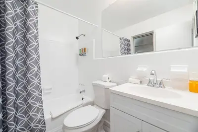 a white bathroom with a toilet and a sink at Just Off Wilton Drive Apt 2 in Fort Lauderdale