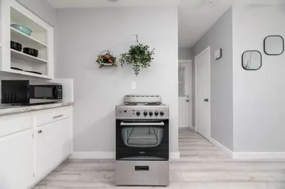 a kitchen with a stove and white cabinets at Just Off Wilton Drive Apt 3 in Fort Lauderdale