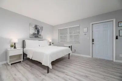 a bedroom with a white bed and a white door at Just Off Wilton Drive Apt 3 in Fort Lauderdale