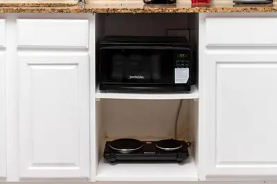 a microwave oven sitting inside of a kitchen cabinet at Just Off Wilton Drive Apt 5 in Fort Lauderdale