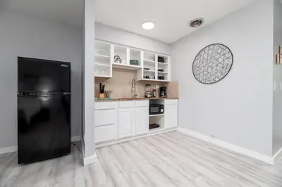 a kitchen with white cabinets and a black refrigerator at Just Off Wilton Drive Apt 5 in Fort Lauderdale
