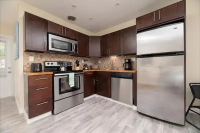 a kitchen with wooden cabinets and a stainless steel refrigerator at Just Off Wilton Drive Apt 6 in Fort Lauderdale