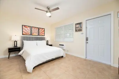 a bedroom with a white bed and a ceiling fan at Just Off Wilton Drive Apt 7 in Fort Lauderdale