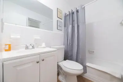 a white bathroom with a toilet and a sink at Just Off Wilton Drive Apt 7 in Fort Lauderdale