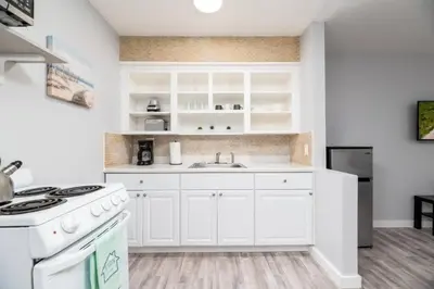 a white kitchen with a sink and a stove at Just Off Wilton Drive Apt 8 in Fort Lauderdale