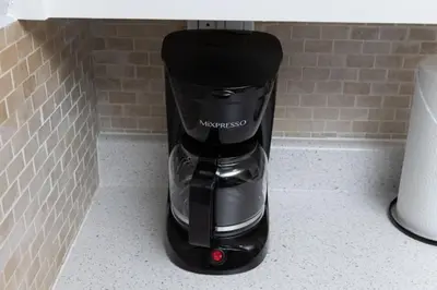 a black coffee maker sitting on a counter at Just Off Wilton Drive Apt 8 in Fort Lauderdale