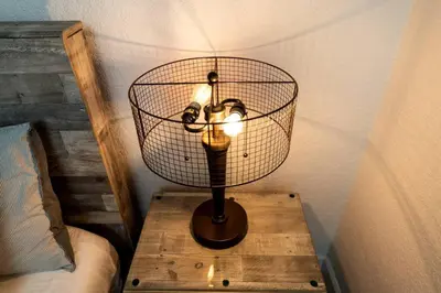 a lamp on a wooden table next to a bed at Comfy Condos at Middle River Apt 2 in Fort Lauderdale