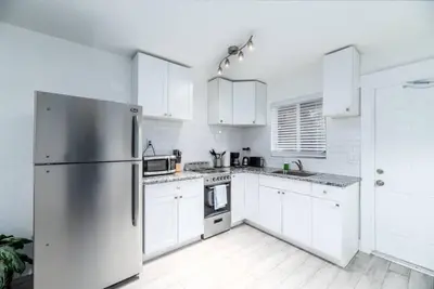 a kitchen with white cabinets and a stainless steel refrigerator at Comfy Condos at Middle River Apt 2 in Fort Lauderdale